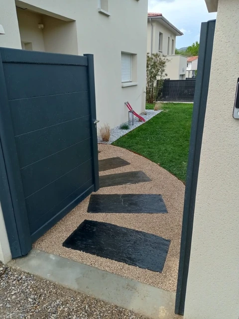 Entrée de maison moderne avec portillon anthracite ouvert sur allée piétonne