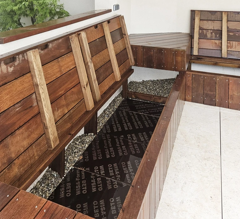 Abri de jardin moderne en bois avec toit plat et débord, situé dans un jardin résidentiel avec pelouse et végétation