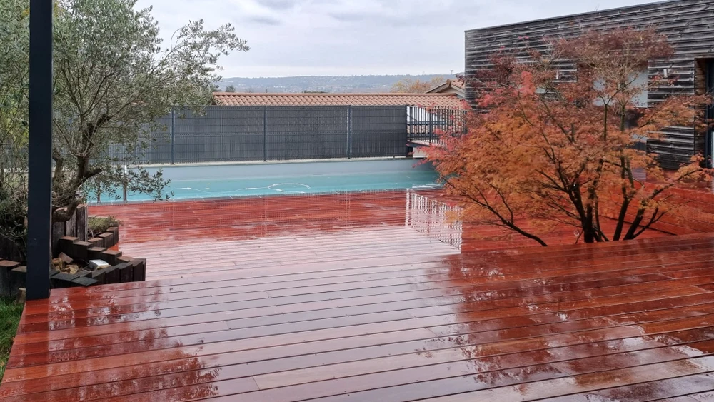 Chantier extérieur de construction d'une terrasse surélevée en bois avec escalier et garde-corps