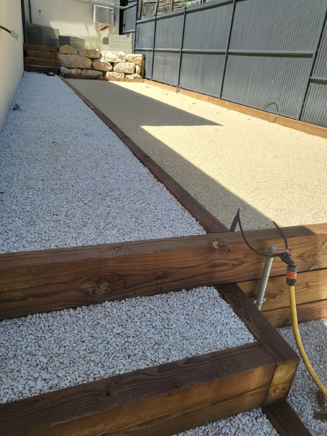Terrasse extérieure contemporaine avec escaliers en béton et bois menant à pelouse