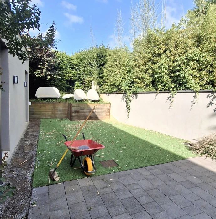 Terrasse extérieure résidentielle avec revêtement de sol en carrelage gris clair, murs ocre, ouvertures vitrées coulissantes