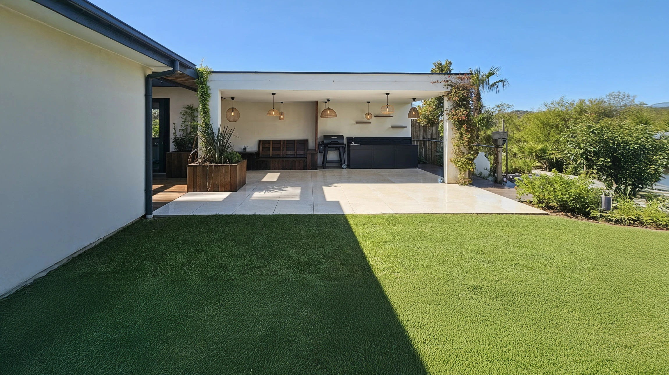 Une belle pelouse artificielle dans la cour d'entrée avec de jolies fleurs et des arbustes l'entourant