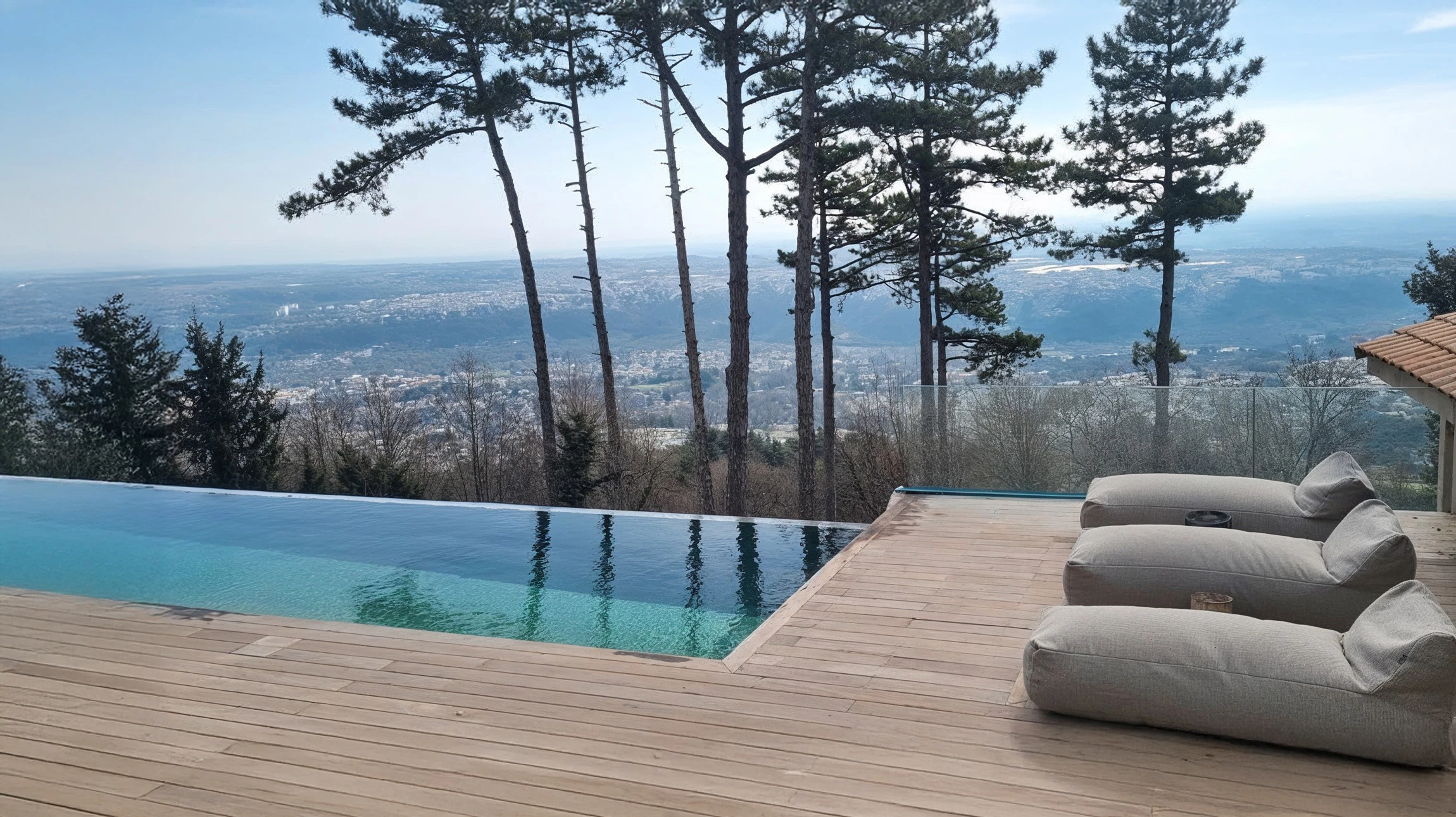 Jardin contemporain avec terrasse en bois composite, deux fauteuils Acapulco bleu turquoise et noir sur structure métallique
